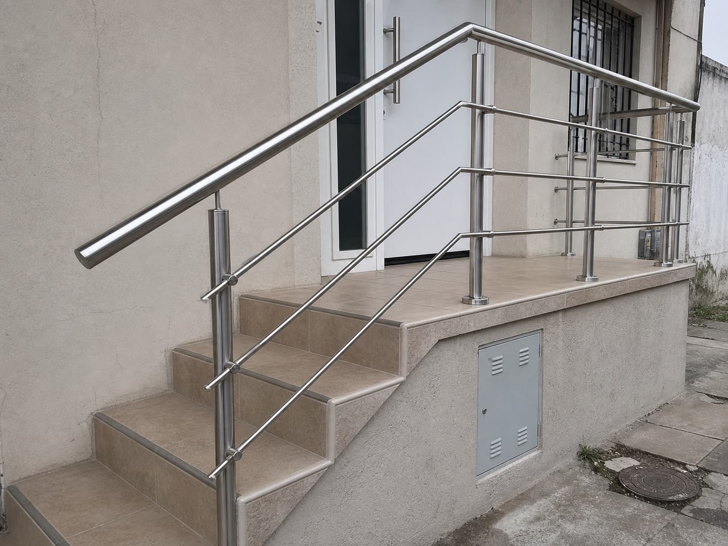 Baranda y pasamanos de acero inoxidable instalados en entrada de vivienda