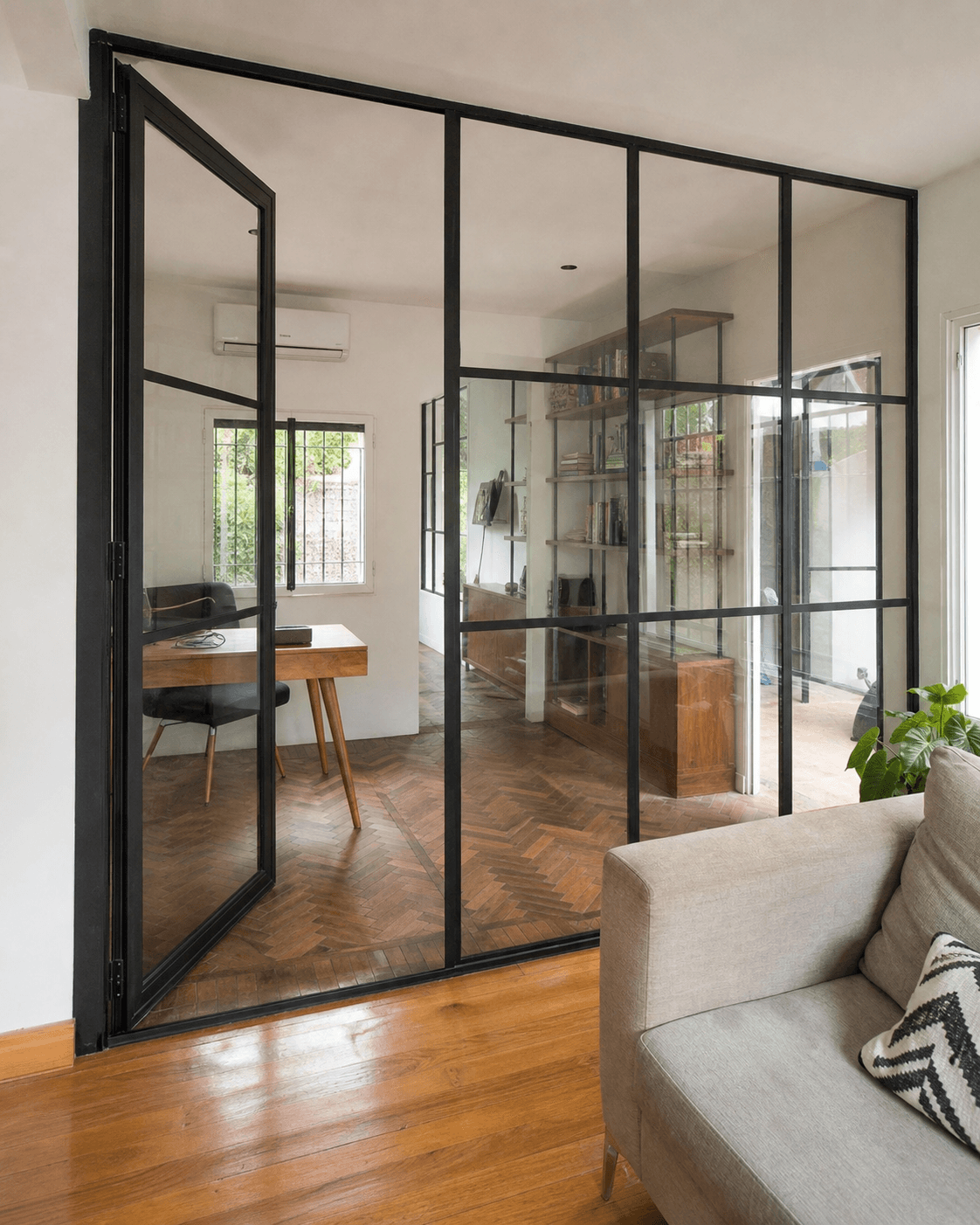 Cerramiento interior de hierro negro y vidrio con puerta