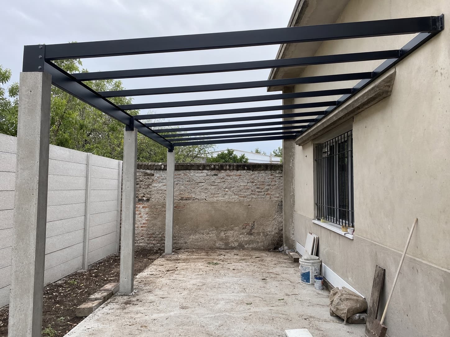 Estructura metálica negra para techo de cochera instalada en patio