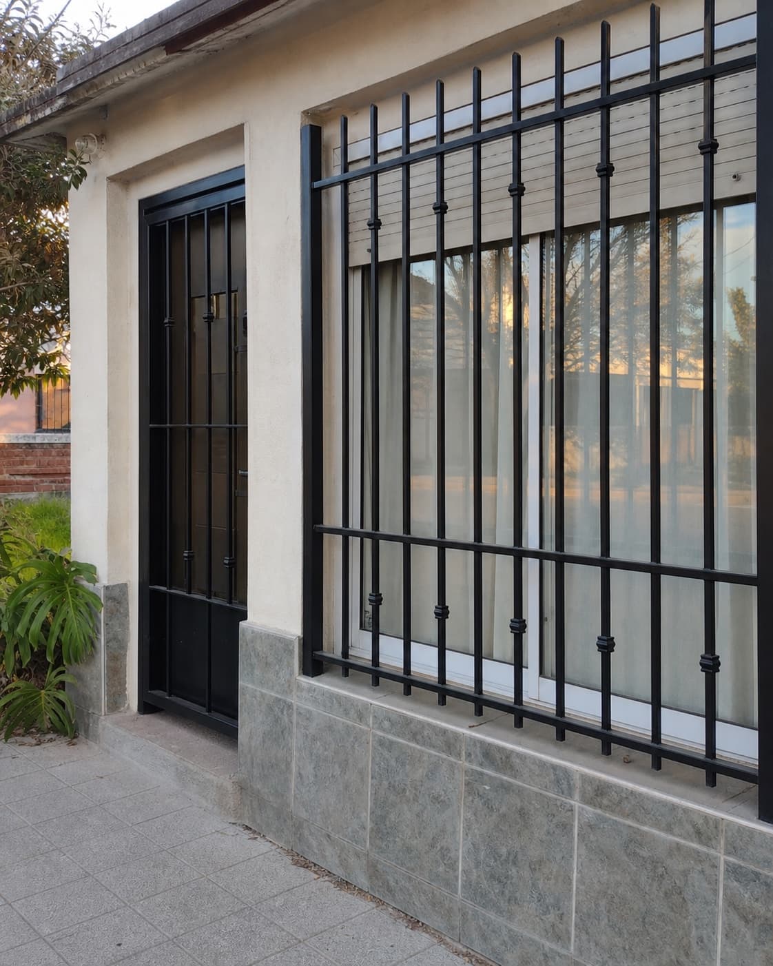 Rejas negras de seguridad instaladas en ventana y puerta de vivienda