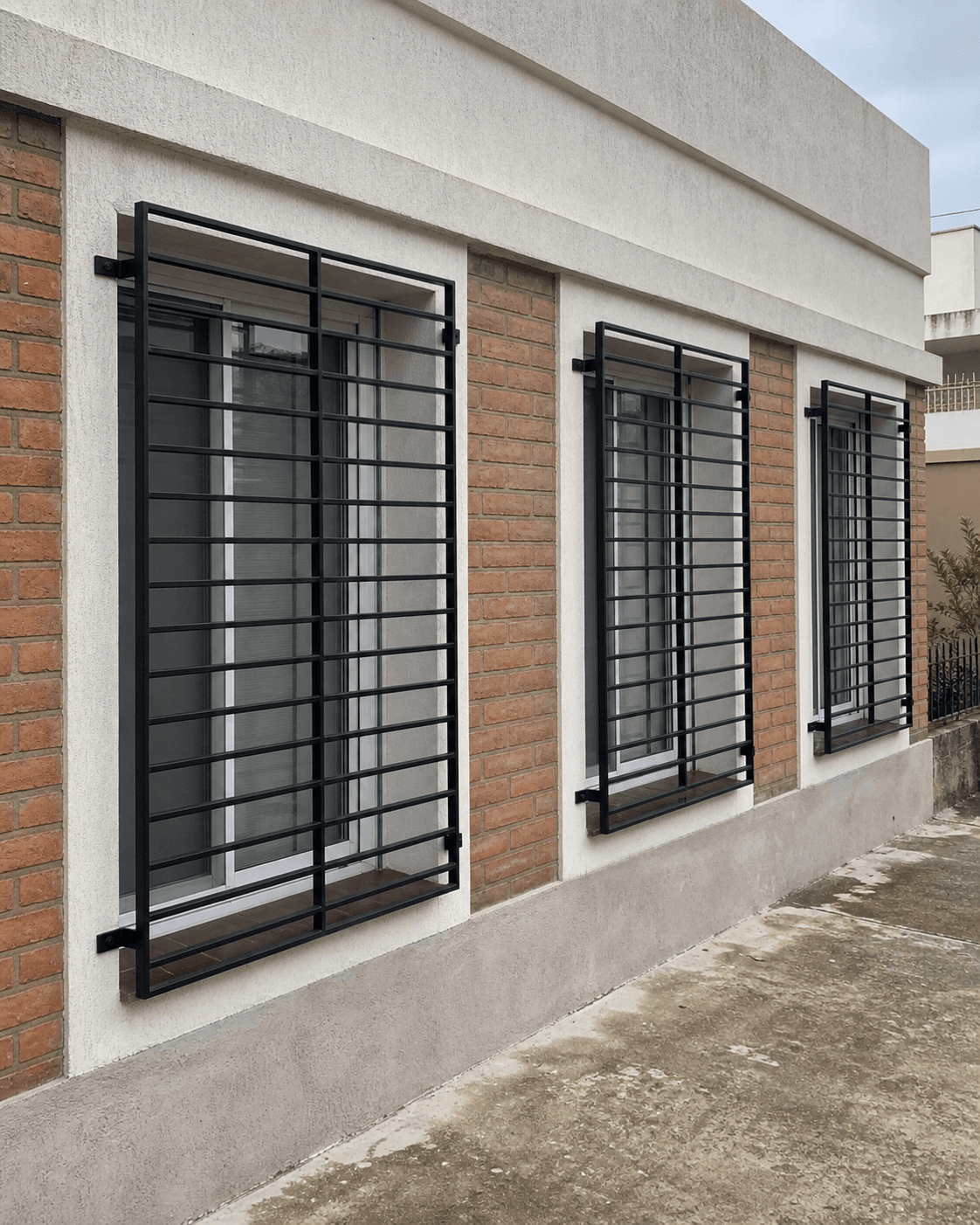 Tres rejas negras modernas instaladas en ventanas de una vivienda